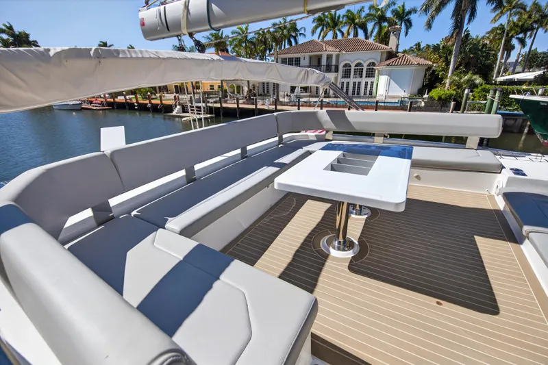  Yacht Photos Pics Luxurious Leopard 50 yacht deck with seating, table, and waterfront view, 2021 model.