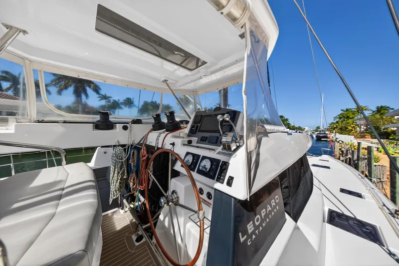  Yacht Photos Pics 2021 Leopard 50 catamaran cockpit with steering wheel, ropes, and navigation equipment.
