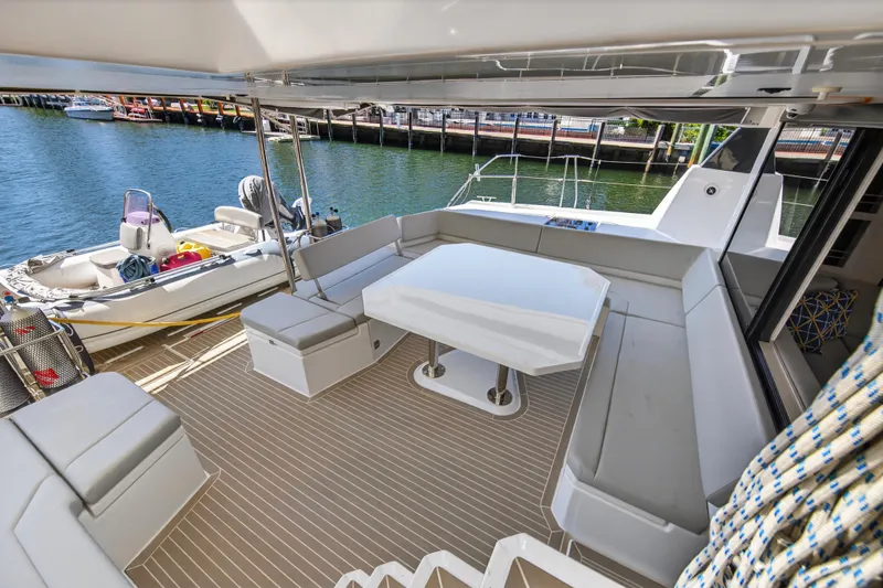  Yacht Photos Pics Leopard 50 yacht deck with seating and table, docked by the water, 2021 model.