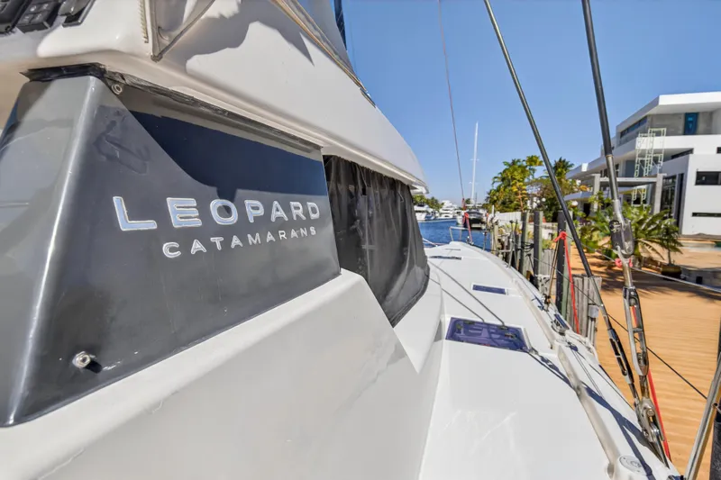  Yacht Photos Pics 2021 Leopard 50 catamaran docked, showcasing sleek design and modern architecture in the background.
