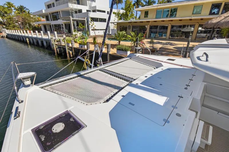  Yacht Photos Pics Leopard 50 catamaran docked by waterfront homes, showcasing spacious deck and modern design.