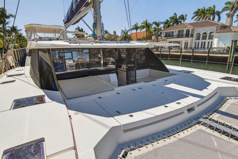  Yacht Photos Pics Luxurious 2021 Leopard 50 catamaran docked near waterfront homes, showcasing spacious deck.