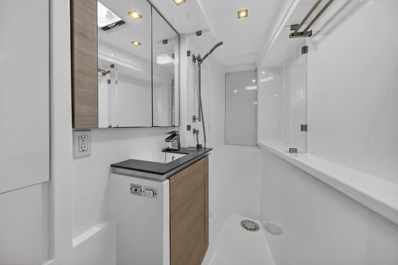  Yacht Photos Pics Modern yacht bathroom with sleek design, featuring a shower and mirrored cabinets, Leopard 50, 2021 model.