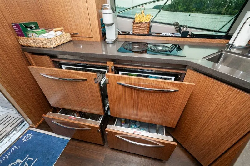Lady Gail Yacht Photos Pics 2018 Sea Ray L550 Flybridge kitchen with wooden cabinets, open drawers, and countertop appliances.