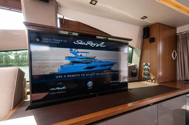 Lady Gail Yacht Photos Pics Flat-screen TV displaying Sea Ray L550 Flybridge yacht interior, 2018 model, in luxurious setting.