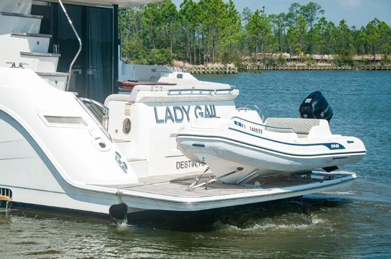 Lady Gail Yacht Photos Pics 2018 Sea Ray L550 Flybridge yacht with tender on water, surrounded by trees.