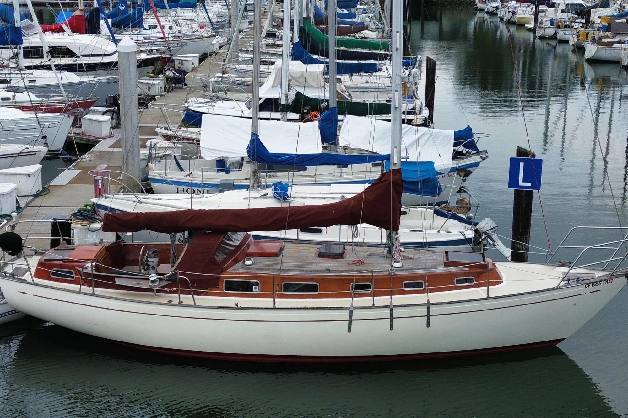 Vintage 1978 Vindo 50 sailboat docked in a marina, surrounded by other boats.