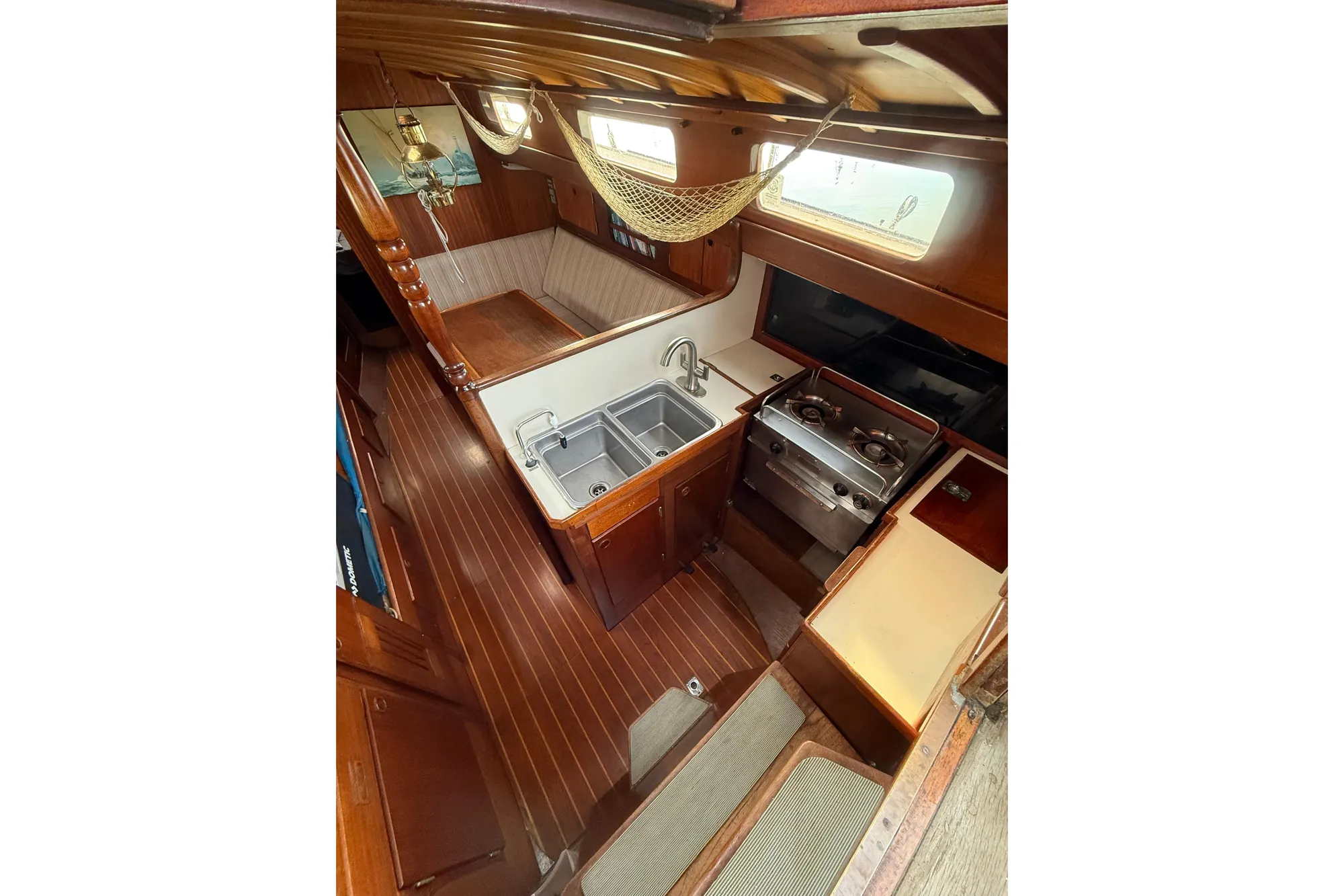 Vintage 1978 Vindo 50 yacht interior with wooden finish and compact kitchen area.