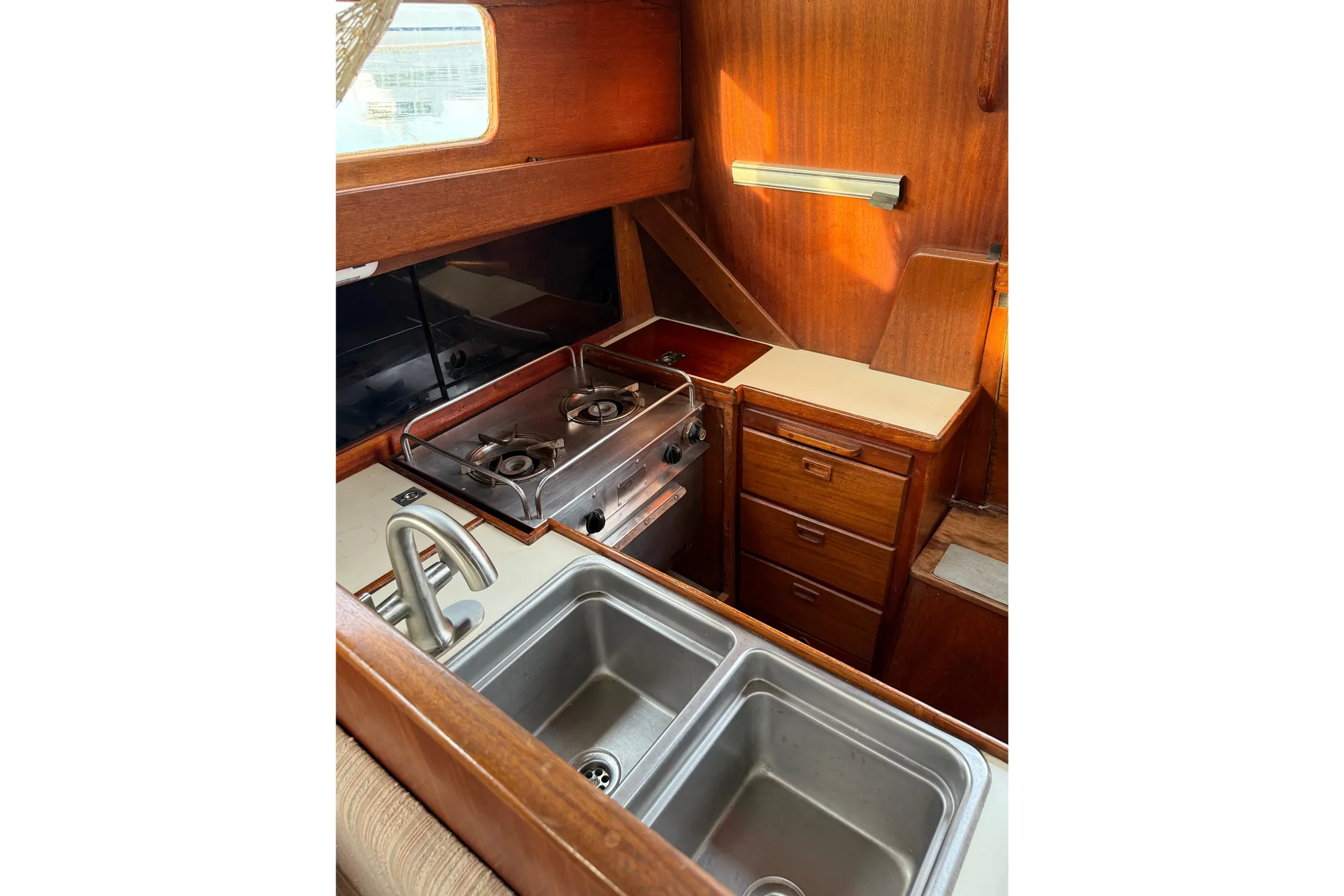 1978 Vindo 50 yacht kitchen with dual sink, stove, and wooden cabinetry.