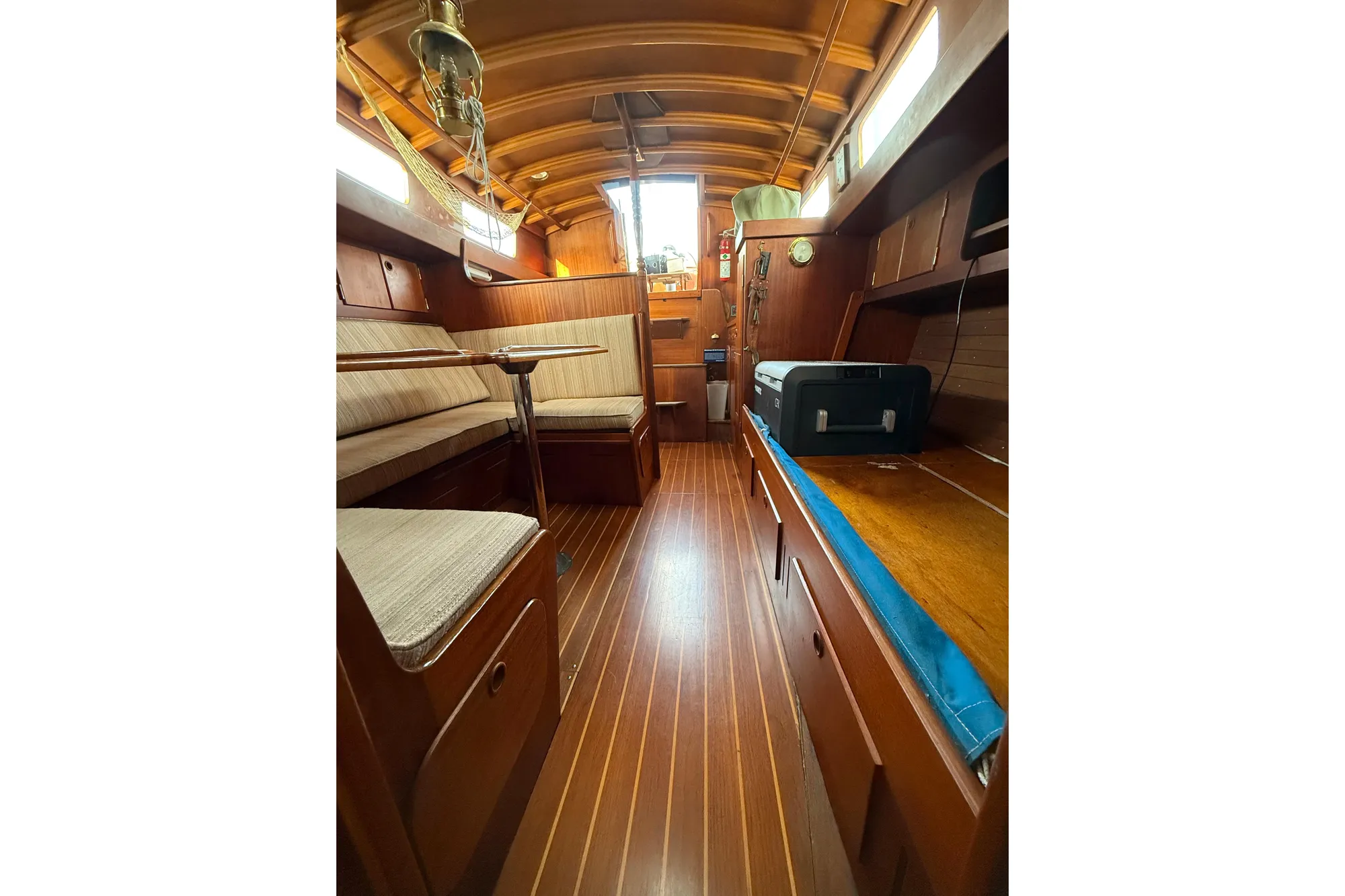 Interior of a 1978 Vindo 50 sailboat with wooden furnishings and seating area.