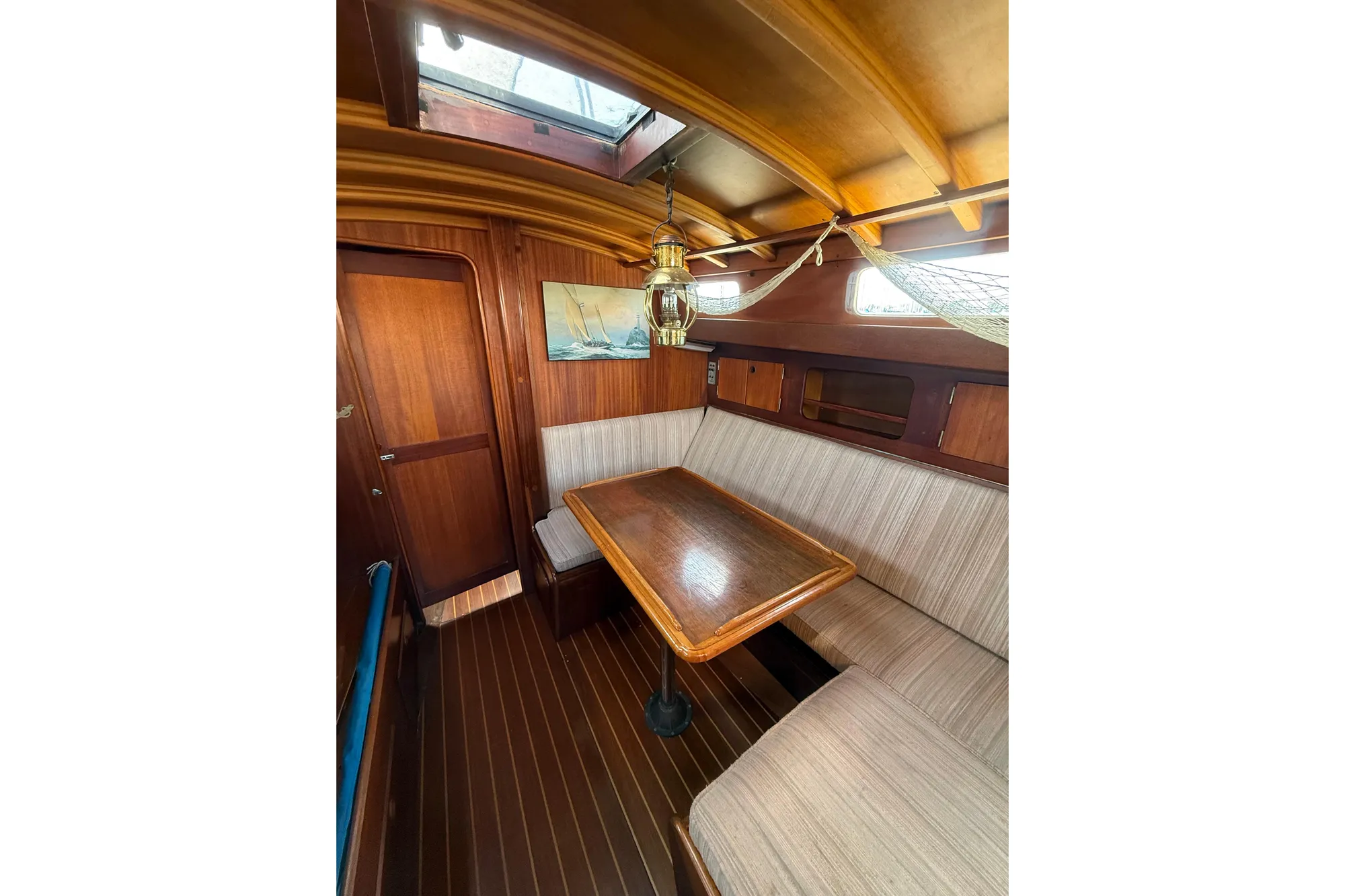 Interior of 1978 Vindo 50 sailboat with wooden table and seating area.