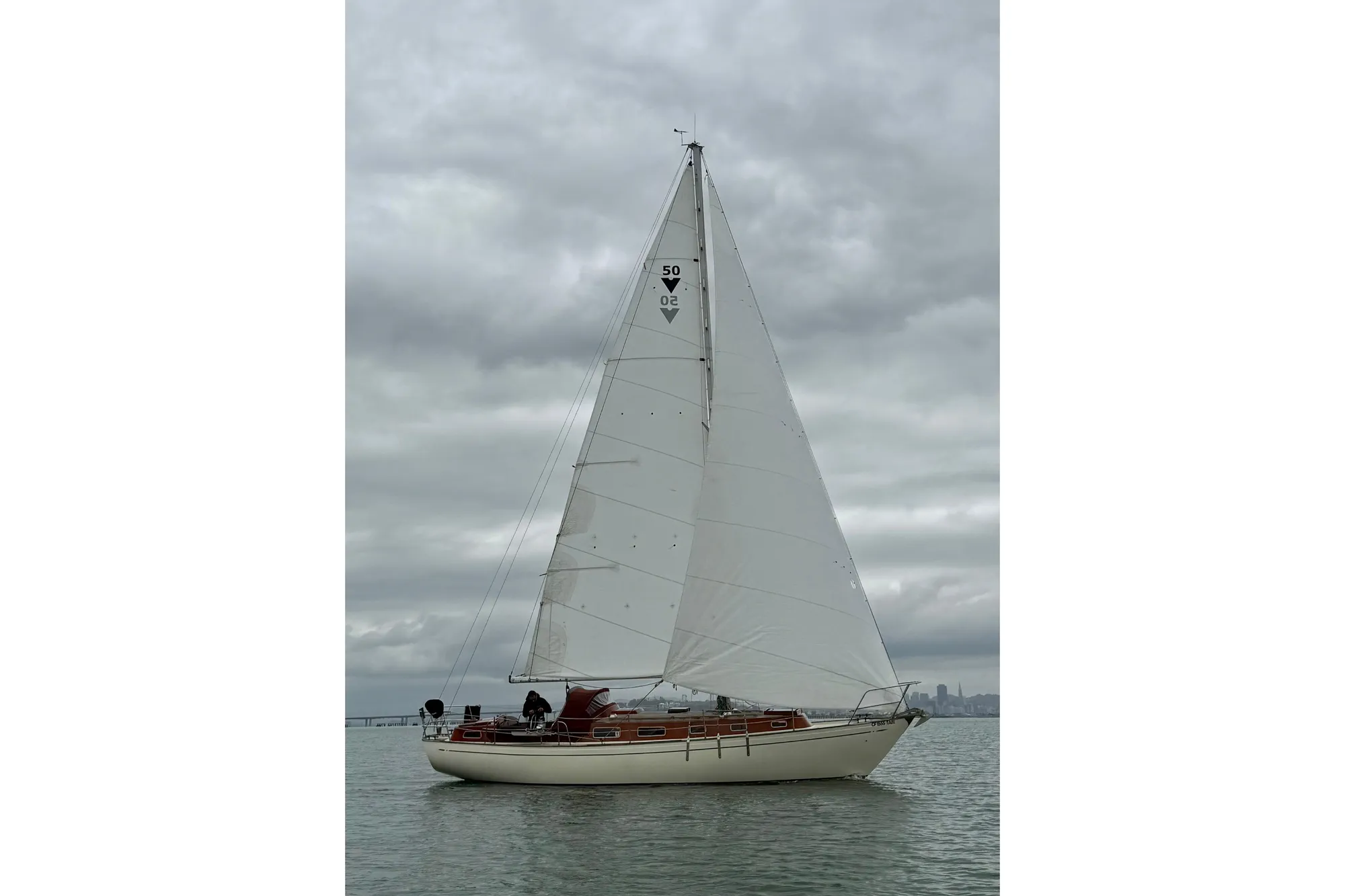 Vintage 1978 Vindo 50 sailboat on calm waters under cloudy skies.
