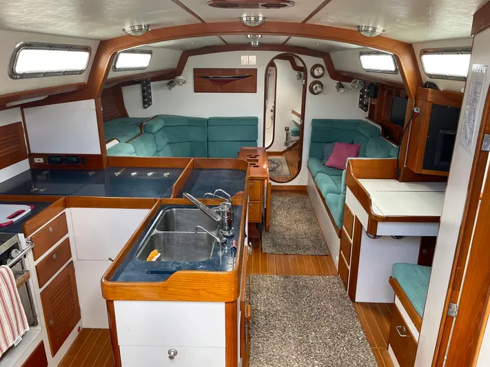 Condor Yacht Photos Pics Interior of 1996 J Boats J/160 sailboat with kitchen, seating, and wood accents.