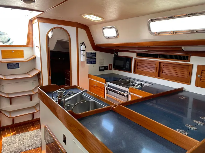 Condor Yacht Photos Pics Interior of 1996 J Boats J/160 yacht, featuring a modern kitchen with wood accents and appliances.