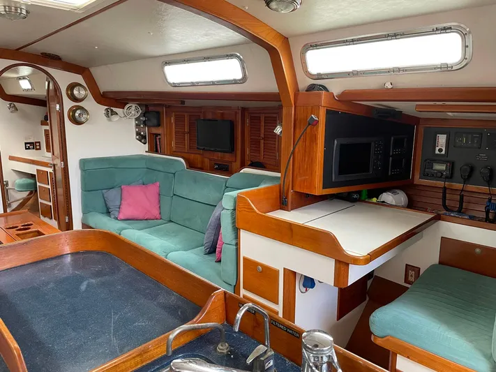 Condor Yacht Photos Pics Interior of a 1996 J Boats J/160 sailboat with teal seating and wooden cabinetry.