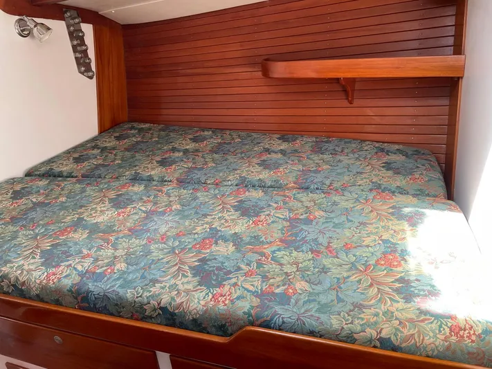Condor Yacht Photos Pics Cabin interior of 1996 J Boats J/160 with floral-patterned bedding and wooden paneling.