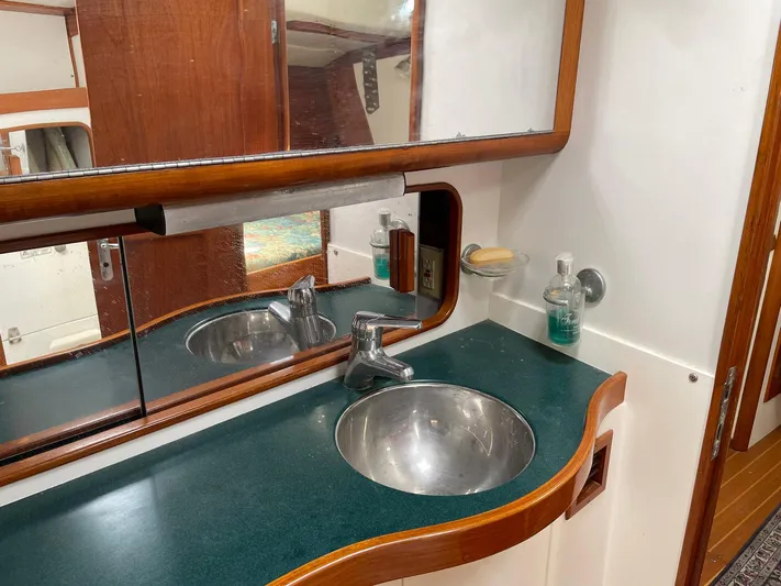 Condor Yacht Photos Pics Bathroom sink area on a 1996 J Boats J/160 yacht with mirror and wooden accents.