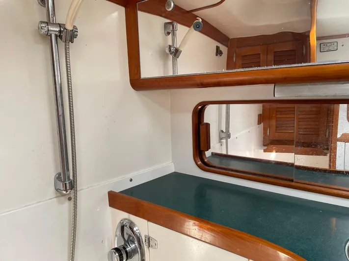 Condor Yacht Photos Pics Interior of 1996 J Boats J/160 yacht bathroom with mirror and wooden accents.