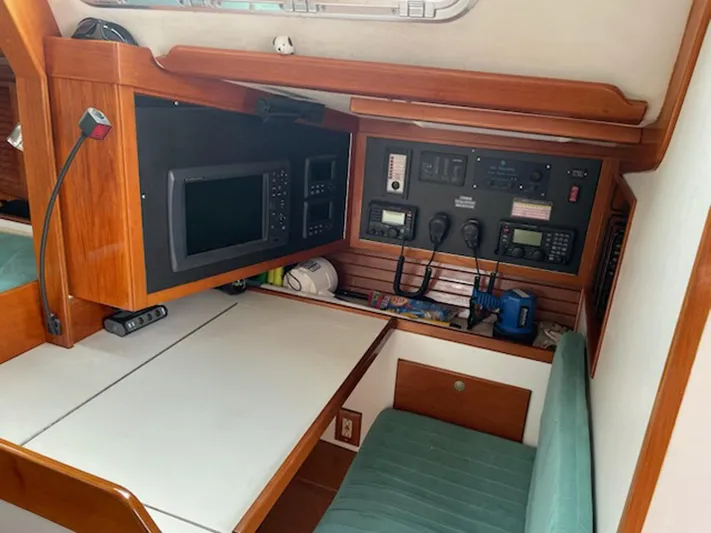 Condor Yacht Photos Pics Navigation station inside a 1996 J Boats J/160 sailboat, featuring control panels and seating.