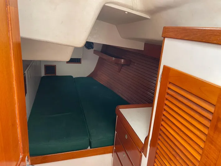 Condor Yacht Photos Pics 1996 J Boats J/160 cabin interior with green cushions and wooden cabinetry.