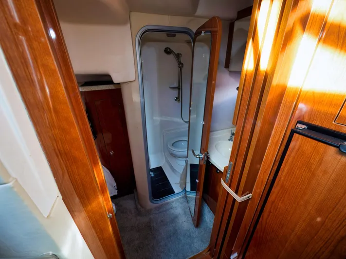 Syrenka Yacht Photos Pics 2008 Regal Commodore 4060 yacht bathroom with wooden cabinetry and compact shower.