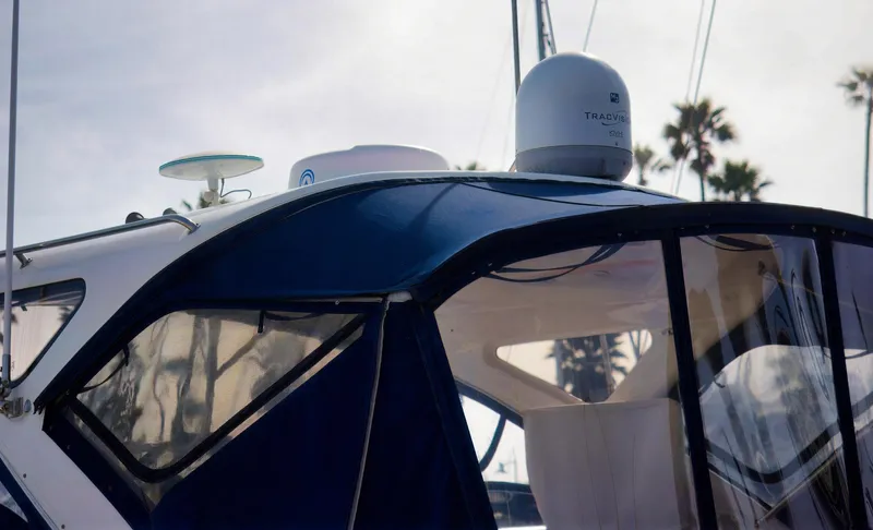 Syrenka Yacht Photos Pics 2008 Regal Commodore 4060 boat with blue canopy and radar, docked near palm trees.