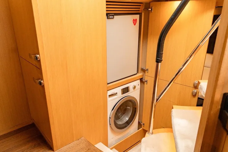  Yacht Photos Pics Laundry area in 2012 Princess V72 yacht with washing machine and wooden cabinetry.