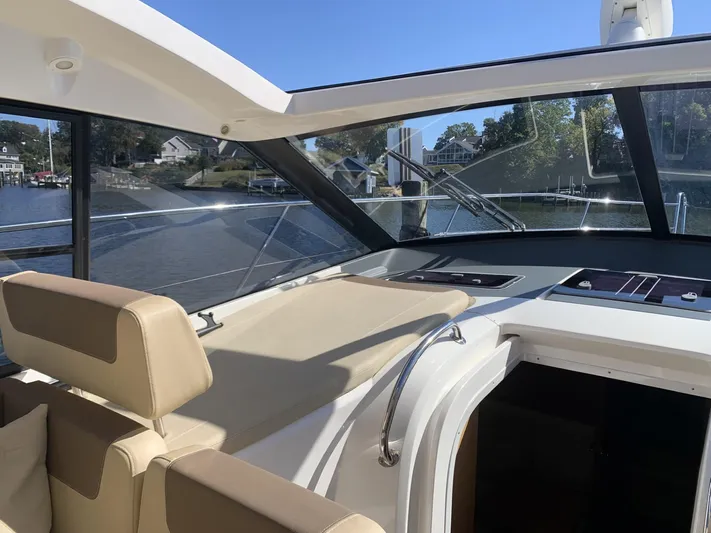  Yacht Photos Pics Interior view of 2015 Bavaria S36 Coupe yacht with beige seating and large windows.
