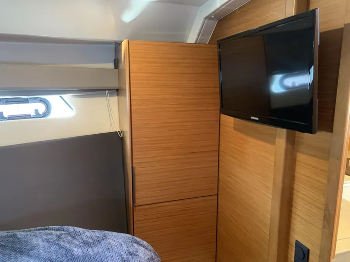  Yacht Photos Pics Interior of 2015 Bavaria S36 Coupe with wooden cabinetry and mounted TV.