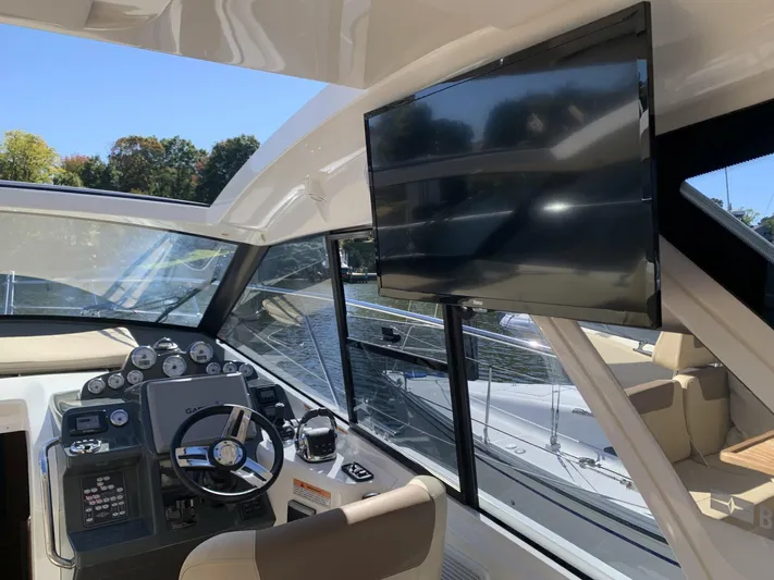  Yacht Photos Pics Interior of 2015 Bavaria S36 Coupe yacht with steering wheel and mounted TV screen.
