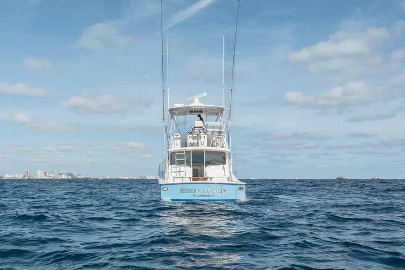 Reelin N Dealin Yacht Photos Pics 2018 Viking 37 Billfish yacht on open sea with city skyline in background.