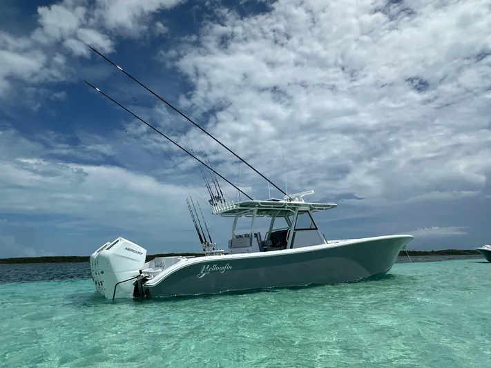  Yacht Photos Pics 2024 Yellowfin 39 boat in clear turquoise water under a partly cloudy sky.