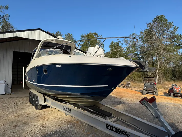 Rollin With The Flow Yacht Photos Pics 2012 Sea Ray 310 Sundancer boat on trailer, parked outdoors near a building.