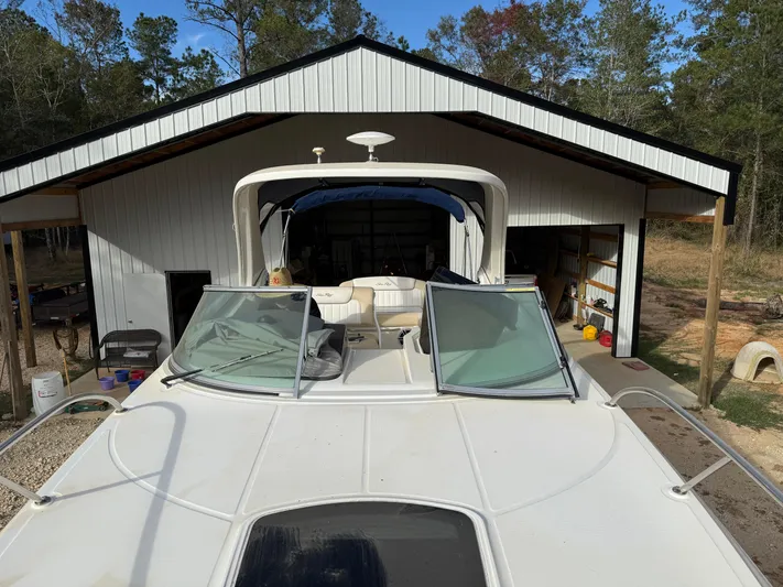 Rollin With The Flow Yacht Photos Pics 2012 Sea Ray 310 Sundancer boat docked in a shed, surrounded by trees.