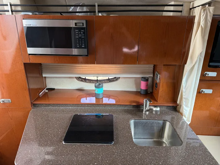 Rollin With The Flow Yacht Photos Pics 2012 Sea Ray 310 Sundancer galley with microwave, sink, and cooktop.