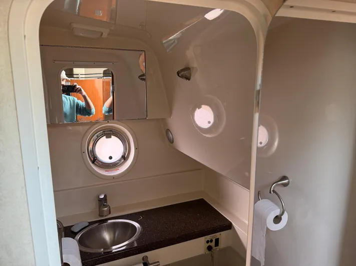 Rollin With The Flow Yacht Photos Pics Interior of 2012 Sea Ray 310 Sundancer bathroom with sink and porthole window.