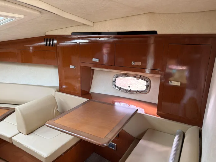 Rollin With The Flow Yacht Photos Pics Interior of 2012 Sea Ray 310 Sundancer with wood cabinetry and seating area.