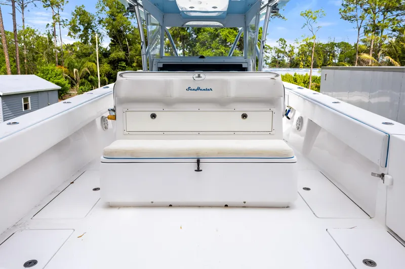 Yacht Photos Pics 2016 SeaHunter 41 Tournament boat interior with seating and storage, surrounded by lush greenery.