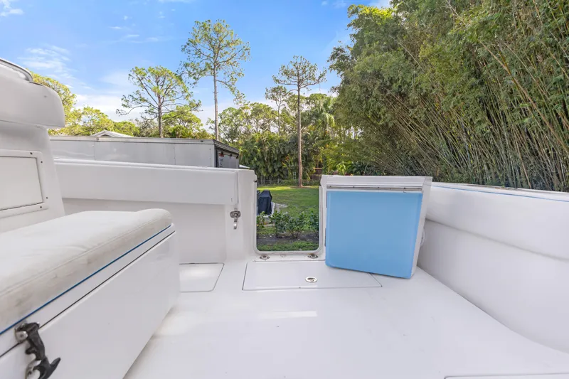  Yacht Photos Pics 2016 SeaHunter 41 Tournament boat interior with seating and cooler, surrounded by lush greenery.