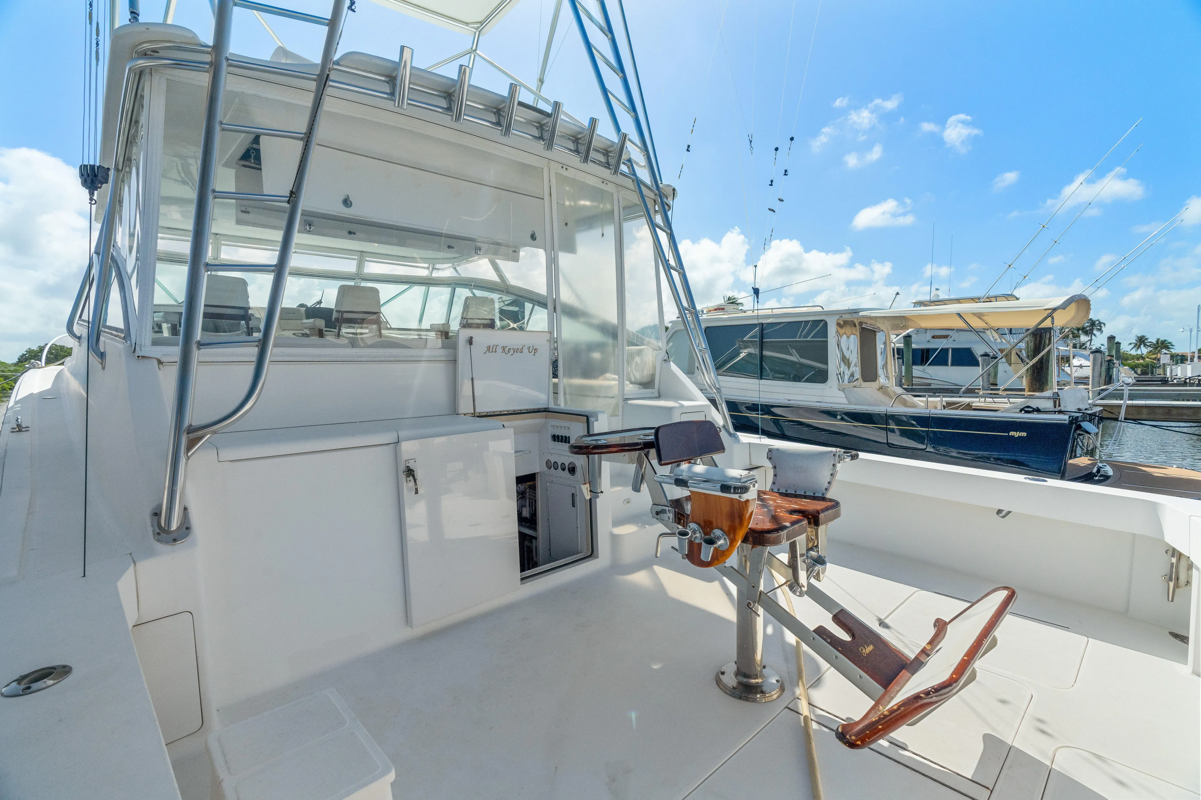 All Keyed Up Yacht Photos Pics 2001 Viking 50 Express yacht with fishing chair, docked under a clear blue sky.