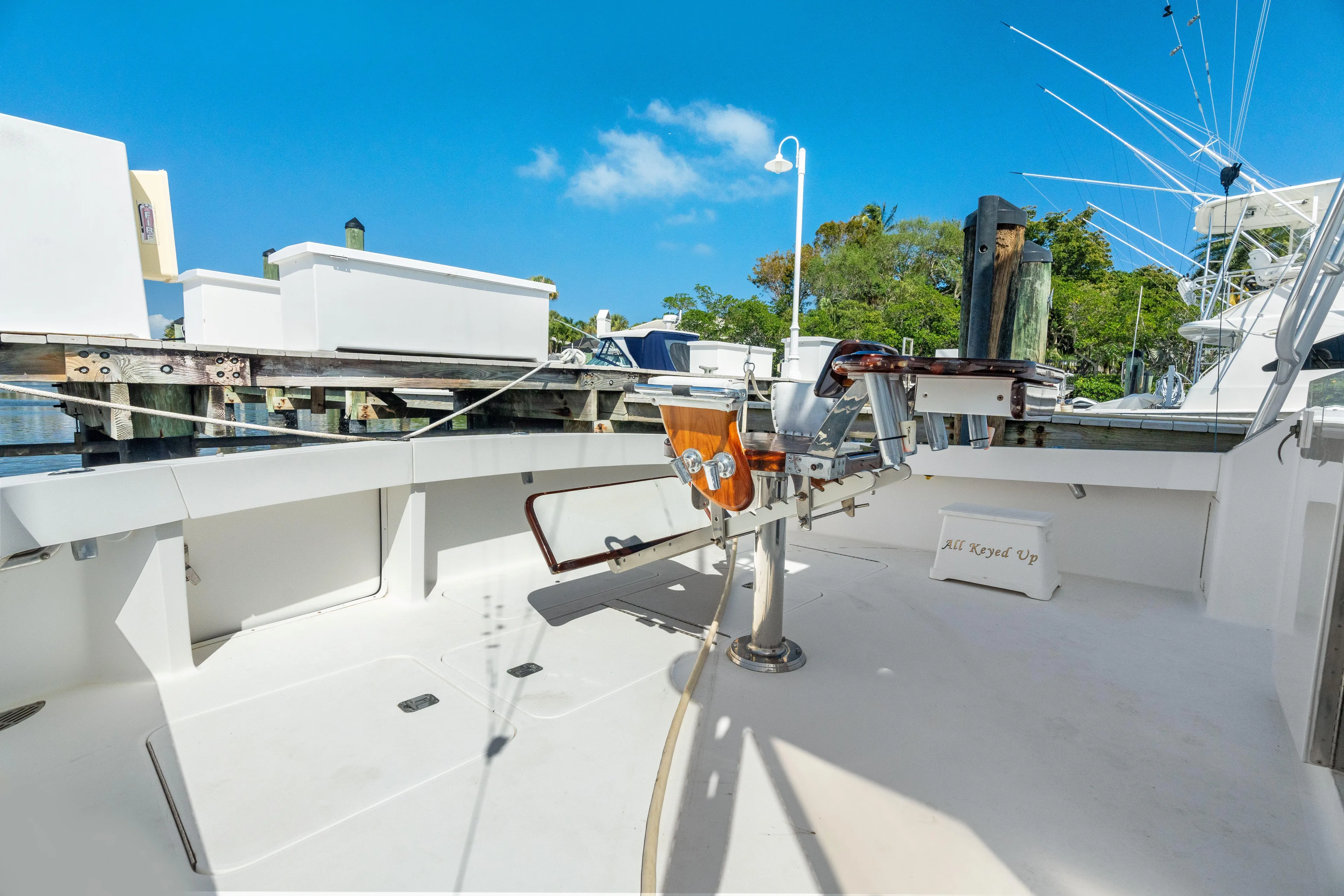 All Keyed Up Yacht Photos Pics 2001 Viking 50 Express boat deck with fishing chair, docked under clear blue sky.