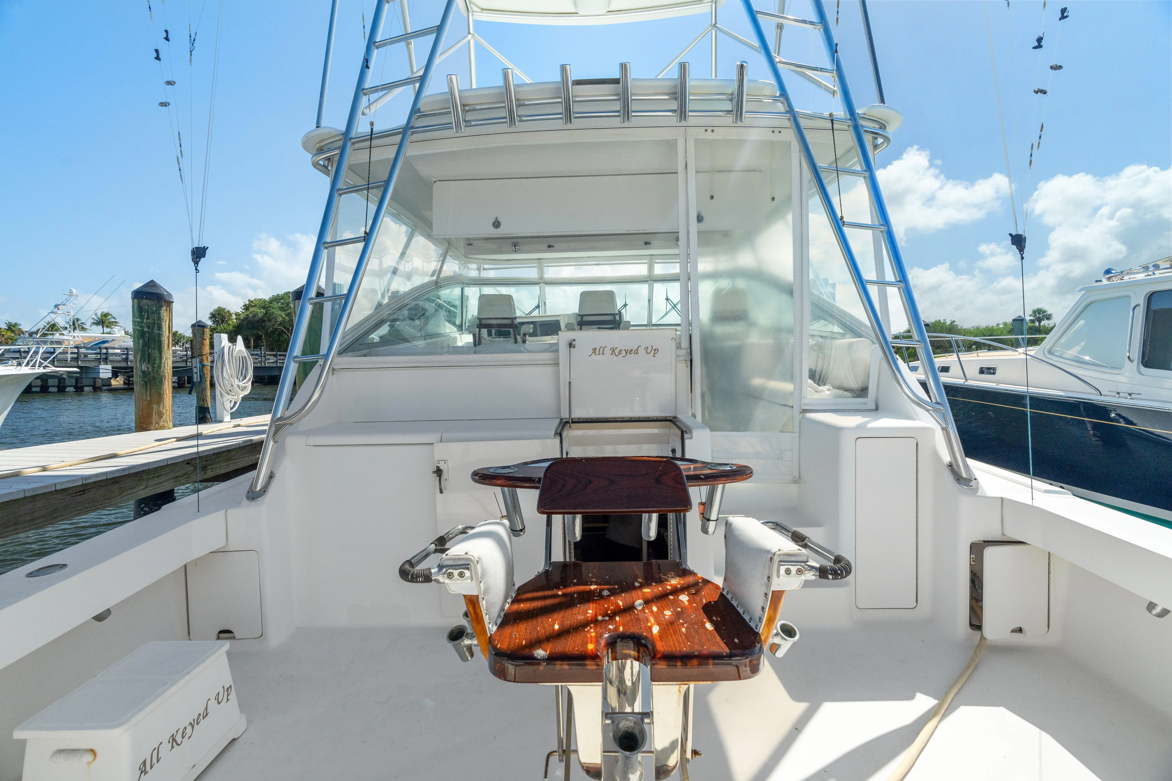 All Keyed Up Yacht Photos Pics 2001 Viking 50 Express yacht cockpit with fishing chair and ladder, docked under clear skies.