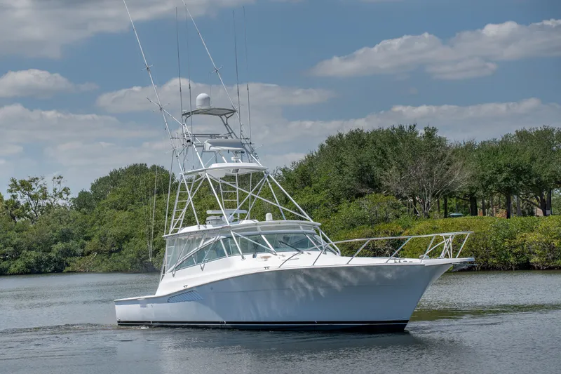 All Keyed Up Yacht Photos Pics 2001 Viking 50 Express yacht cruising on a calm river with lush greenery.