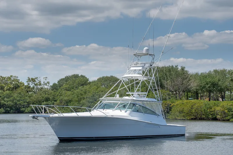 All Keyed Up Yacht Photos Pics 2001 Viking 50 Express yacht on calm water with lush greenery background.