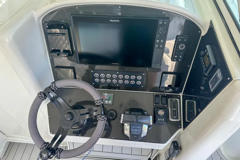  Yacht Photos Pics Control panel of a 2008 Yellowfin 42 Offshore boat with steering wheel and navigation display.