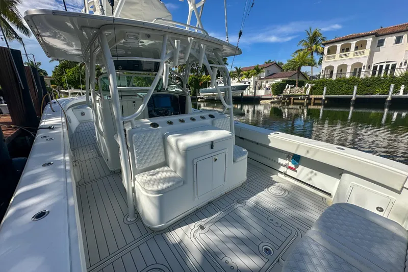  Yacht Photos Pics 2008 Yellowfin 42 Offshore boat docked by waterfront homes, featuring spacious deck and seating.