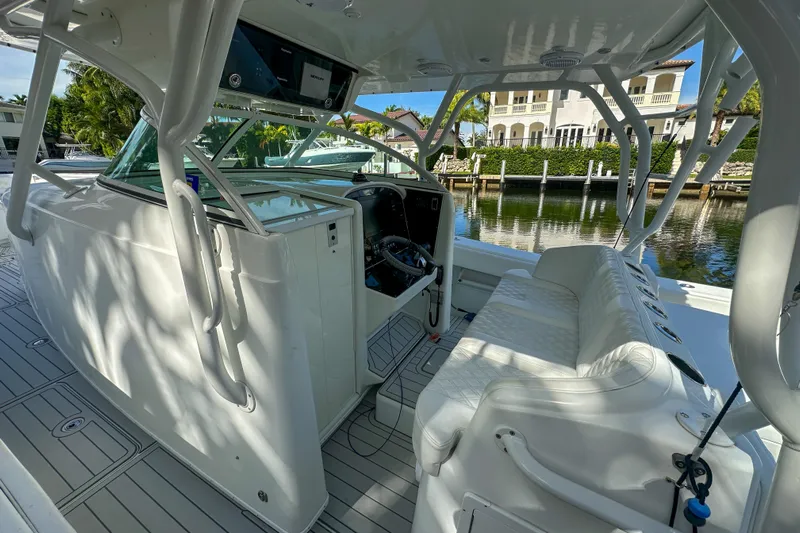  Yacht Photos Pics 2008 Yellowfin 42 Offshore boat interior with seating and helm, docked by waterfront homes.