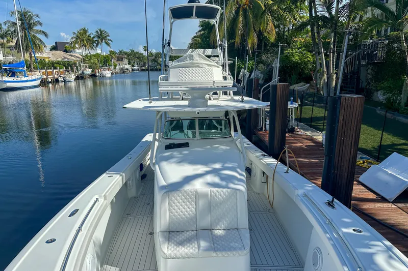  Yacht Photos Pics 2008 Yellowfin 42 Offshore boat docked by a scenic waterfront with palm trees.
