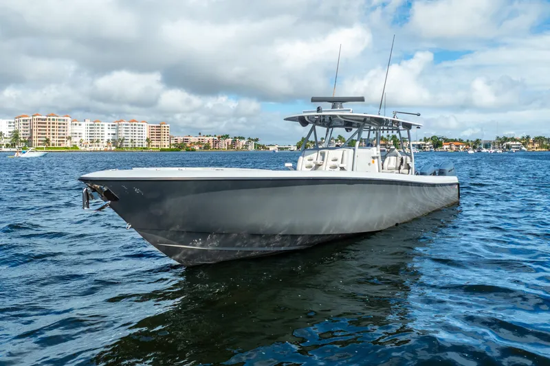 Four Reels Yacht Photos Pics 2021 Contender 44 CB boat on water with coastal buildings in background.