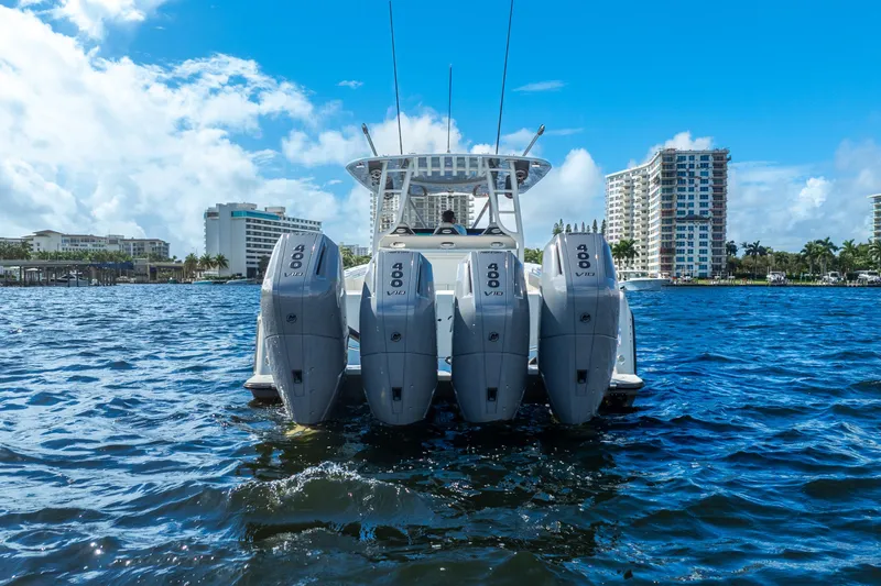 Four Reels Yacht Photos Pics 2021 Contender 44 CB boat with four 400 V10 engines on water, cityscape background.